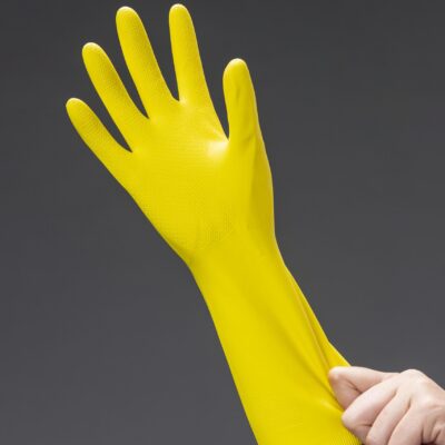 close up image of a woman putting a yellow glove on