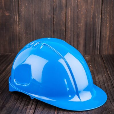 Blue construction hard hat on a wooden background